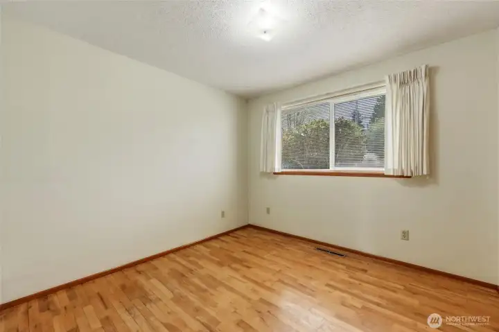 Guest bedroom #1 with oak hardwood flooring.