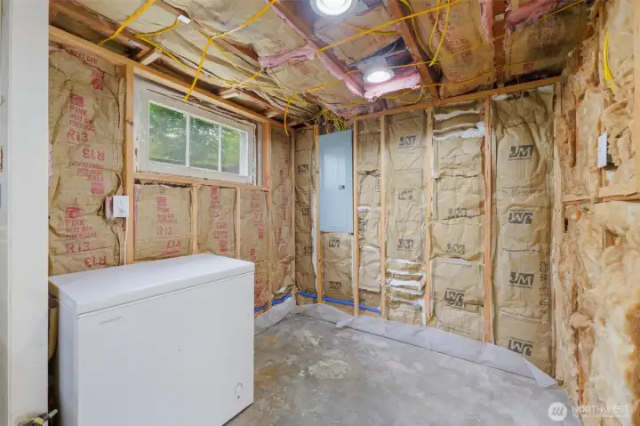 Chest freezer stays, unfinished storage space in utility room. All flooring, insulation and drywall needed to finish space comes with home