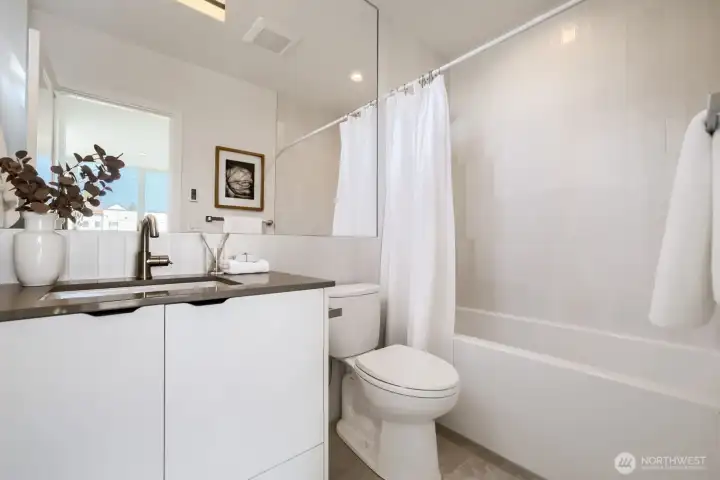 A full bath upstairs in the second primary bedroom.