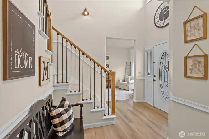 Grand Foyer with Laminate Hardwood Floors and Custom Stair Railing