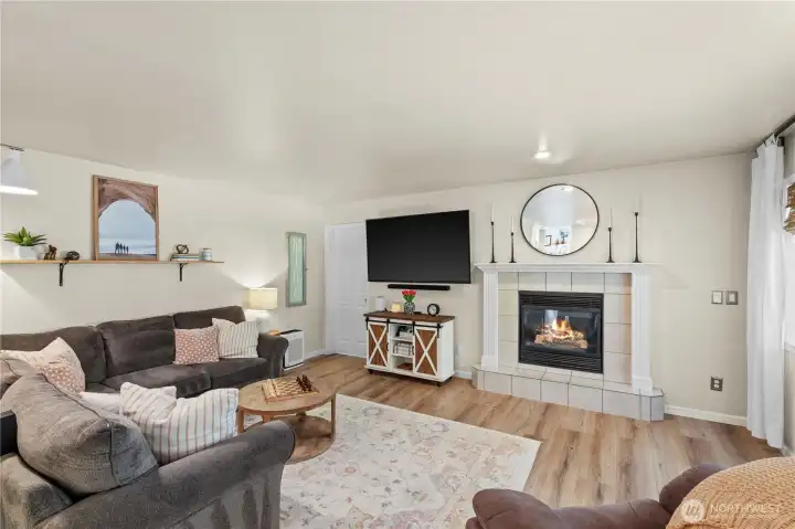 Family Room with Gas Fireplace with White Painted Mantle and Tile Surround. Door on Left leads to Den.