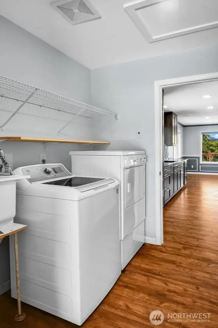 The laundry room includes a washer and dryer, along with a convenient utility sink that adds functionality for everyday household tasks. The laundry room includes a washer and dryer, along with a convenient utility sink that adds functionality for everyday household tasks.