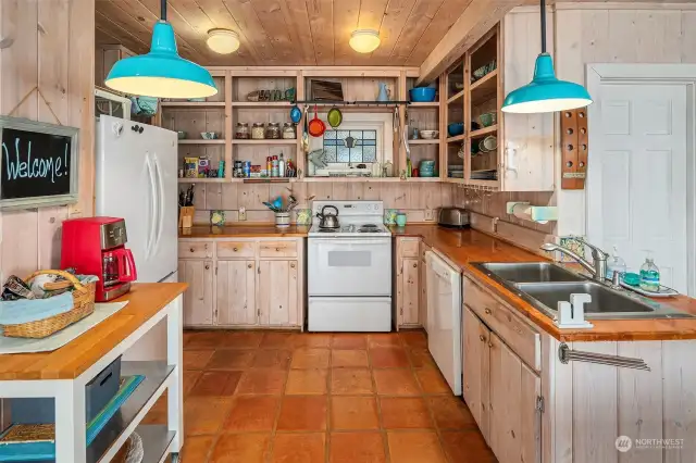 Full kitchen with open shelves, lots of storage and beautiful stained glass window.