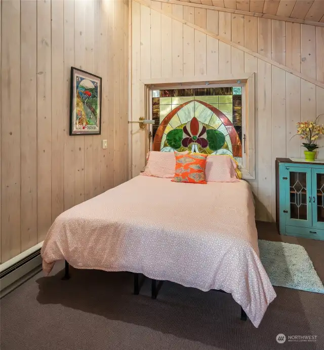 The third upper level bedroom. The vintage stained glass windows are a fun and unique touch.