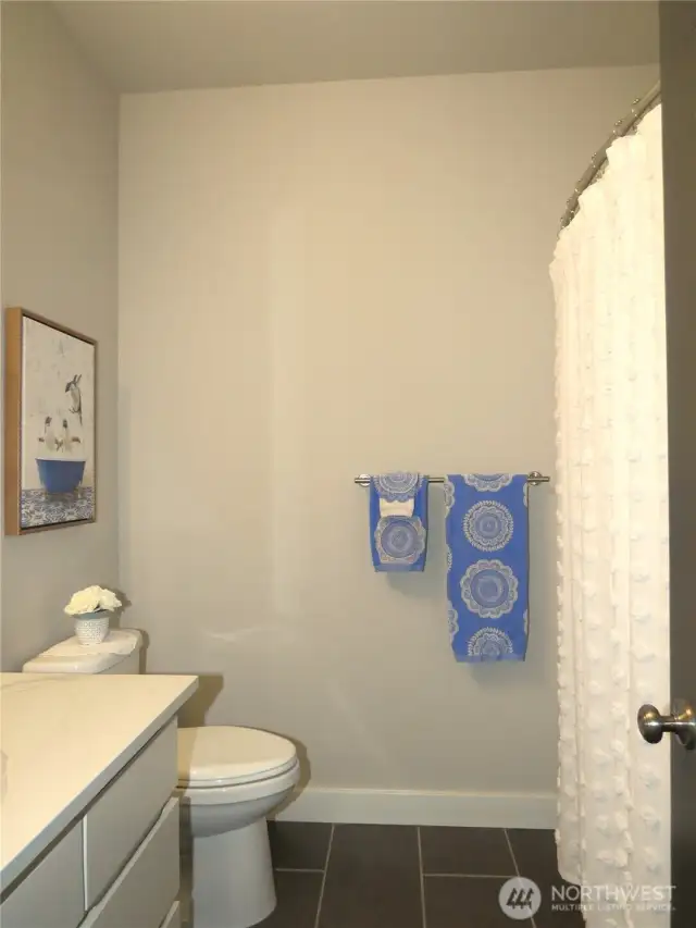 GUESTS WILL ENJOY THE FULL BATH WITH WHITE VANITY & SHOWER/TUB COMBINATION!