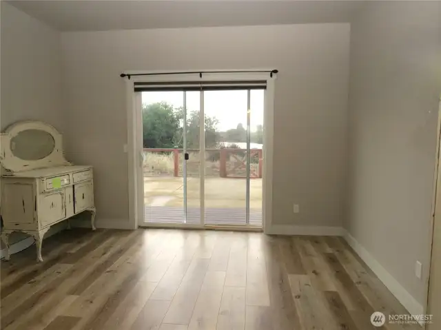 TO THE RIGHT OF THE DINING ROOM IS THE SECLUDED PRIME BEDROOM WHICH CONTINUES WITH VINYL FLOORING AND SLIDING DOORS TO THE TREX DECKING AND EASY CARE FENCED BACK YARD!