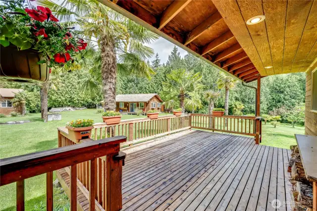 Main home deck looking out to the central compound with the northeast cabin in the center and shop to the left.