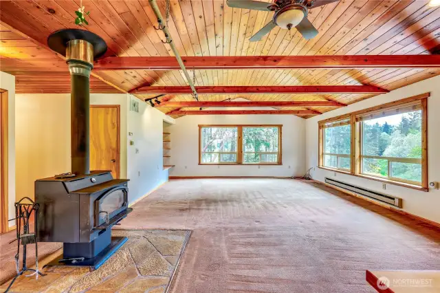 South facing living room with wooden vaulted ceilings and massive windows.