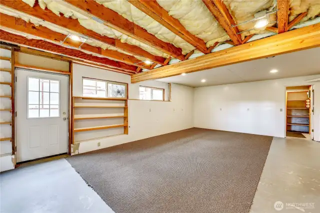 Partially finished room nest to the garage side of the basement.  Door on the left is a "greenhouse" being used to store lumber milled from the land.  Door on the right leads to a walk-in pantry/storage area.