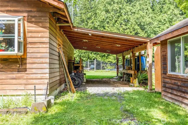 Northeast cabin with carport (has been used as a woodworking area, well lighted and wired) and well pump house on the right.