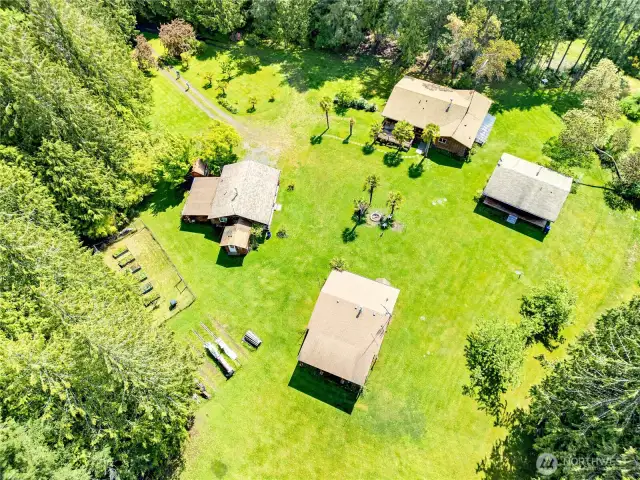 The main home is at the top of the photo, cabins to the left and right and the shop at the bottom.