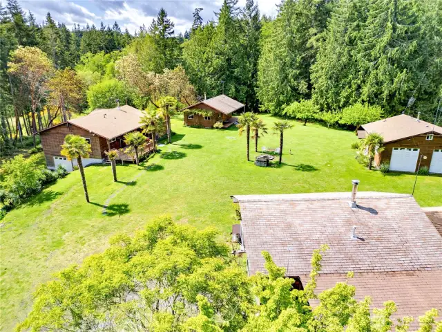 The main home on the left, single story with a full basement.  Cabins in the fore and background with the shop on the right.