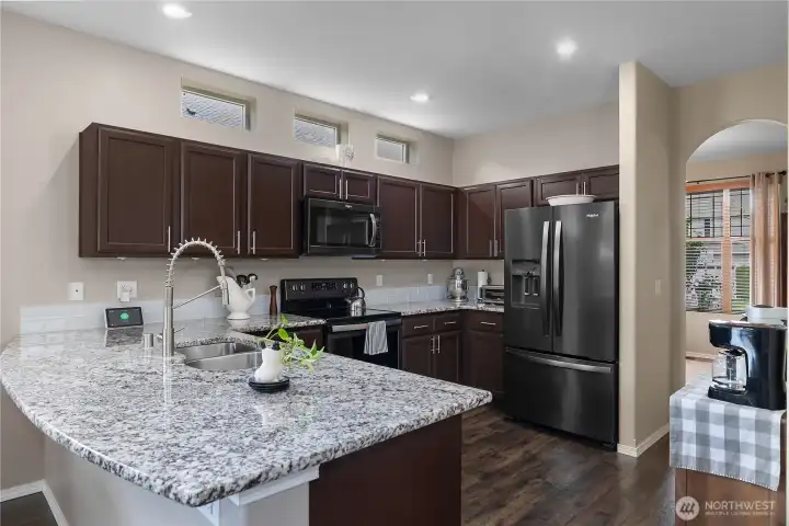 Modern kitchen with quartz countertops, stainless steel appliances, and a convenient eat-in space just off the kitchen.