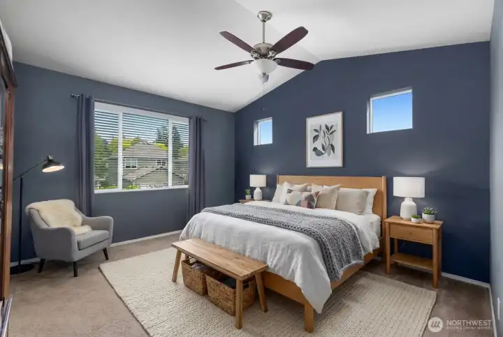 Spacious primary bedroom with vaulted ceilings, a full en suite bathroom featuring a double vanity, and a large walk-in closet.