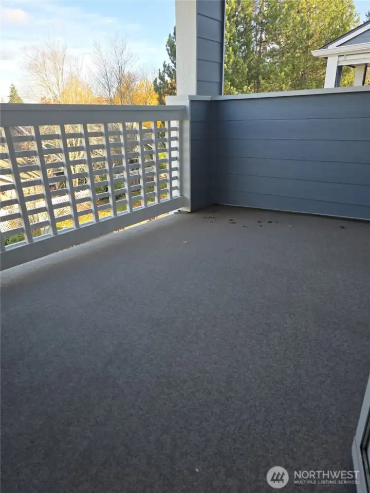 Covered deck overlooks beautifully landscaped grounds.