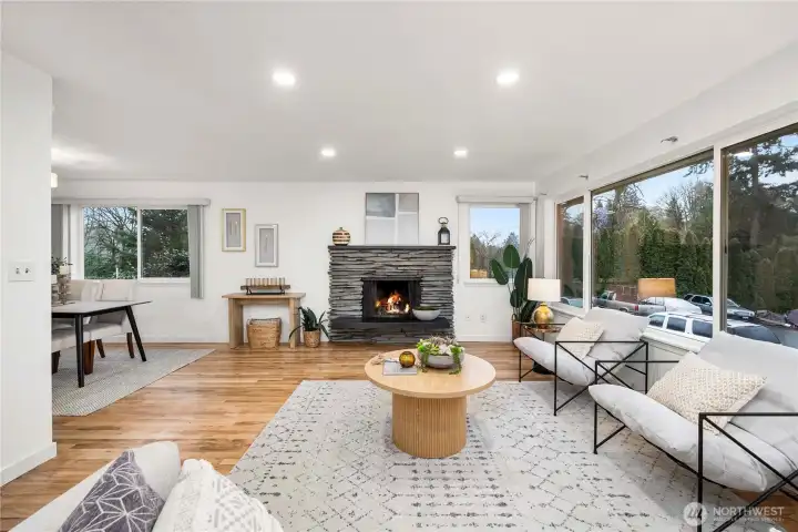 Spacious living room with a cozy fireplace and large picture windows filling this space with natural light.
