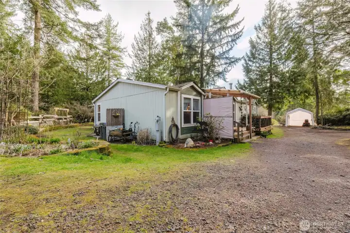 Home with terraced garden beds on the left and covered carport on the right.