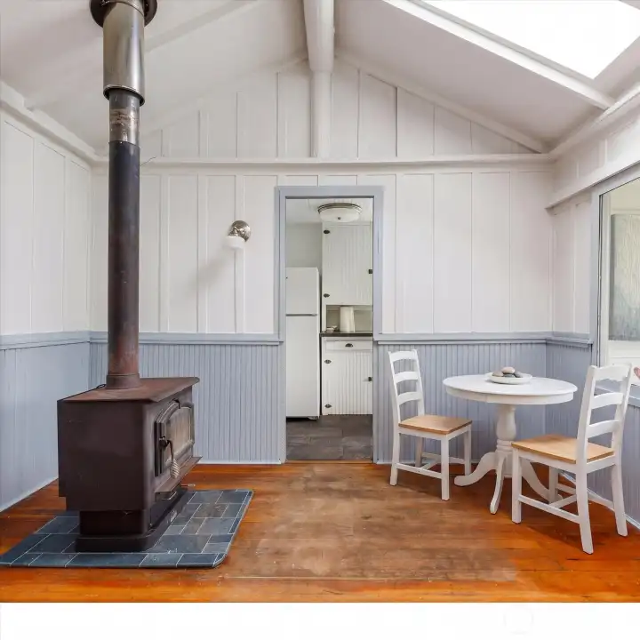 The dining end of this great room, with wood stove.  Table and chairs are virtually staged.