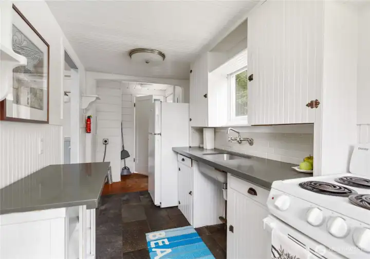 The kitchen is open to the back entry, the utility area for washer/dryer (stack would be best) and the 3/4 bathroom.