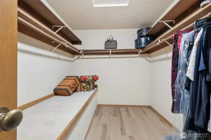 Primary walk in closet with storage.