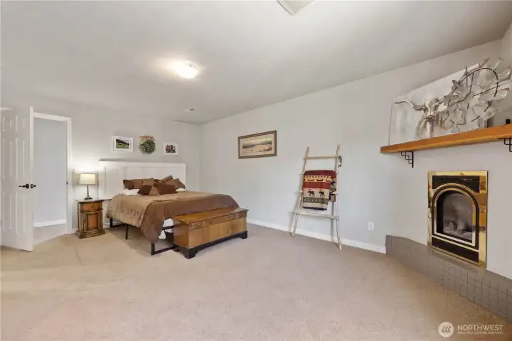 main floor primary bedroom with en suite, propane fireplace, and walk-in closet