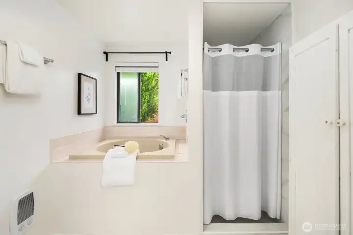 Soaking tub + separate walk-in shower in the en-suite primary bath.