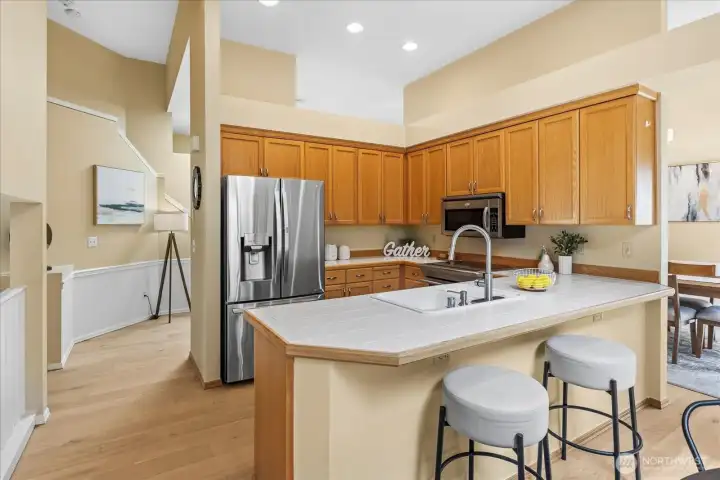 Open kitchen with counter seating and breakfast nook that opens to the oversized deck.
