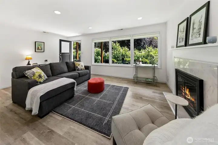 Bright living room with a wood-burning fireplace, marble surround and hearth, recessed lighting and tailored Shade Store window coverings. Bright living room with a wood-burning fireplace, marble surround and hearth, recessed lighting and tailored Shade Store window coverings.