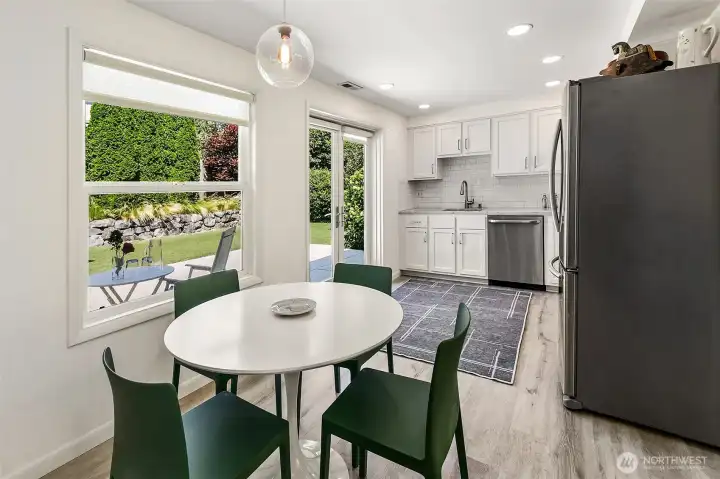 The dining area connects the kitchen directly to the garden terrace through French doors by Lake Washington Windows and Doors. The dining area connects the kitchen directly to the garden terrace through French doors by Lake Washington Windows and Doors.