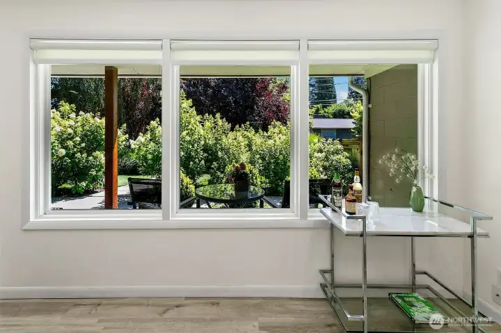 Replacement windows frame the layered garden, where mature trees, hydrangeas and evergreens create privacy and seasonal interest. Replacement windows frame the layered garden, where mature trees, hydrangeas and evergreens create privacy and seasonal interest.