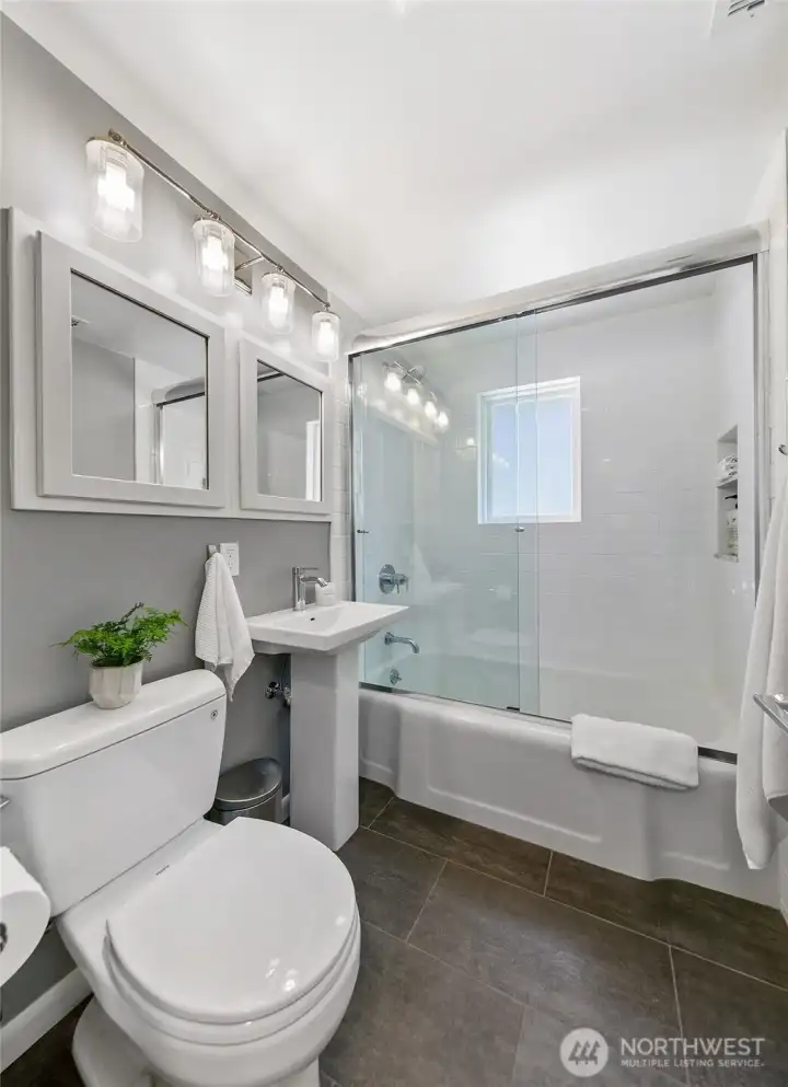 North bathroom with a full tub, glass shower enclosure, tiled niche, Toto toilet and added wall cabinetry for storage. North bathroom with a full tub, glass shower enclosure, tiled niche, Toto toilet and added wall cabinetry for storage.