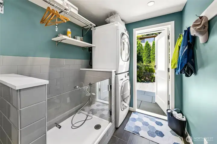 Highly functional mudroom and laundry with a custom tiled dog wash, stacked LG washer and dryer, quartz work surface and heated flooring. Highly functional mudroom and laundry with a custom tiled dog wash, stacked LG washer and dryer, quartz work surface and heated flooring.