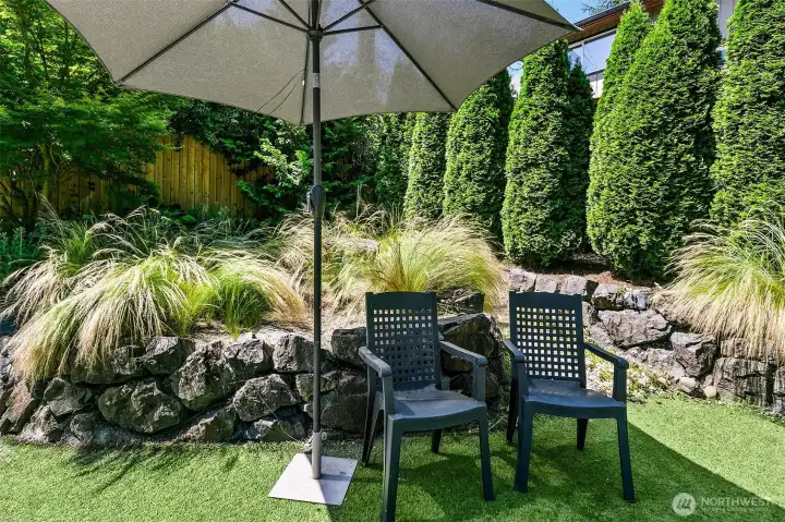 An intimate garden room shaped by rock walls, substantial landscape boulders, ornamental grasses and evergreen screening. An intimate garden room shaped by rock walls, substantial landscape boulders, ornamental grasses and evergreen screening.