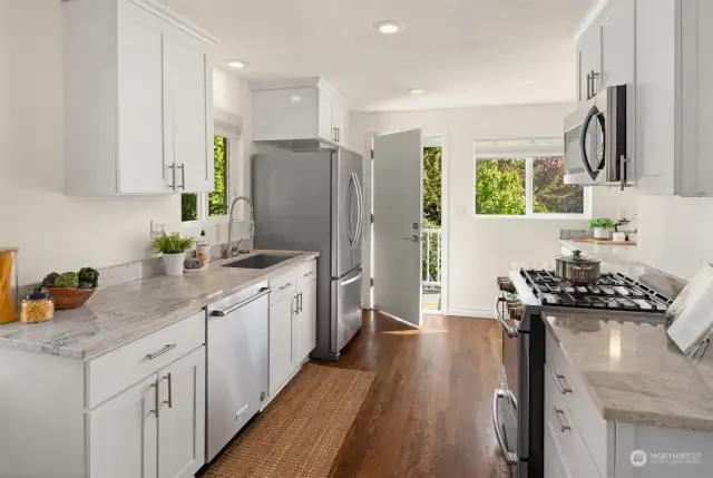 The kitchen has been updated with granite counters, timeless white cabinets and stainless steel appliances that includes a 5-top gas cooktop!