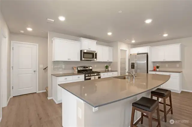 LARGE kitchen island with Powder Bath to the left and convenient Garage Access.