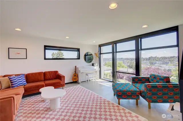 Bright living room with floor to ceiling windows is a wonderful space to relax and enjoy to view or entertain.