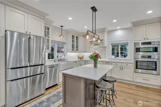 Kitchen with Shaw fir glazed farmhouse sink, Kingston Brass fixtures, Bosch appliances, induction stove top, convection microwave oven, quarts counter tops, Belmont custom glazed cabinets, Duchateau LVP floors and Hinkley light fixtures.