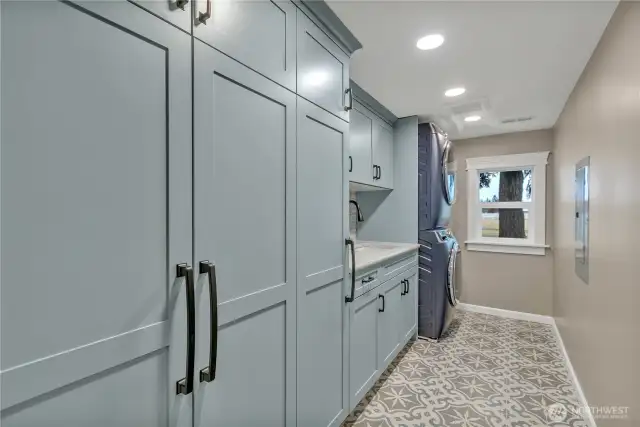 Laundry room with new GE profile washer and dryer, Belmont cabinets, tile floors and modern wash basin sink.