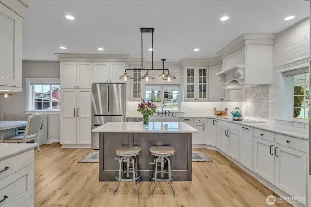 Kitchen with Shaw fir glazed farmhouse sink, Kingston Brass fixtures, Bosch appliances, induction stove top, convection microwave oven, quarts counter tops, Belmont custom glazed cabinets, Duchateau LVP floors and Hinkley light fixtures.