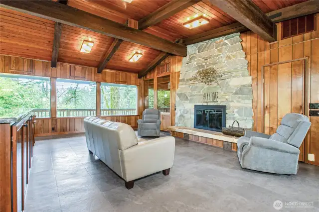 Great room area w/ wall of windows and a floor to ceiling fireplace.