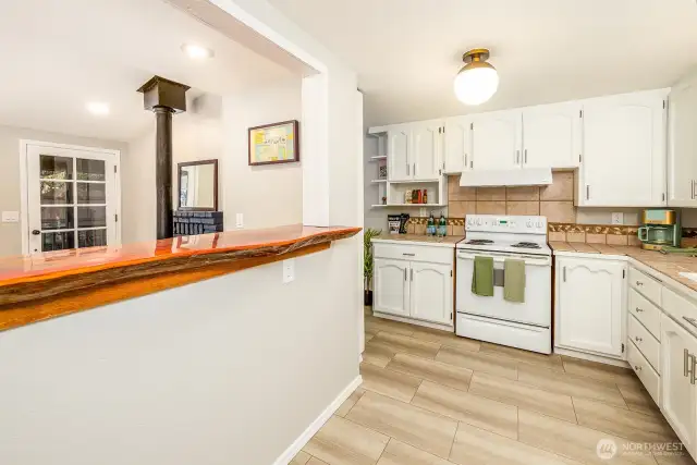 Fully equipped and filled with warmth, this kitchen blends cottage comfort with thoughtful touches—like butcher block counters, open shelving, and that handcrafted live-edge bar. Guests will feel right at home as they cook, connect, and unwind.