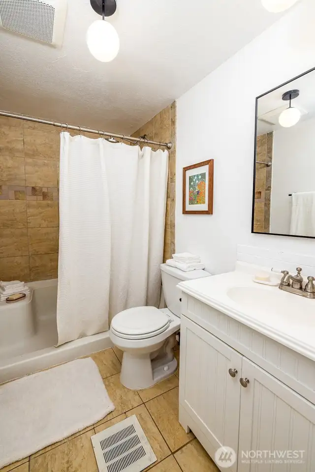 Clean, bright, and efficiently laid out, this second full bath is a game-changer for guest stays. Wood paneling adds a rustic accent, while the shower-tub combo and modern vanity ensure comfort for larger groups or families sharing the space.