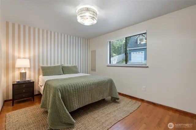 A spacious bedroom on the main floor, complemented by a nearby full bathroom, offers comfort, convenience, and privacy all in one.