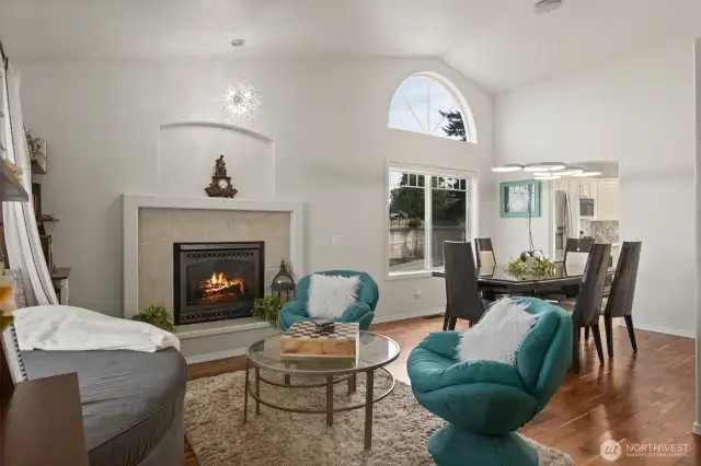Formal living room with cozy gas fireplace opens up to formal dining area.