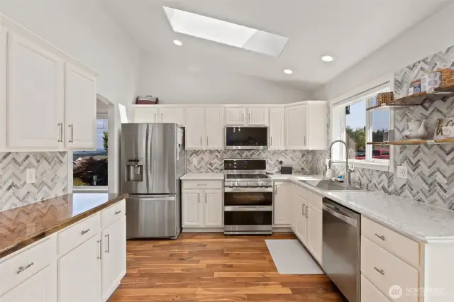 Newer stainless steel appliance, counter tops, sink and tiling make this kitchen a stunning place to gather.