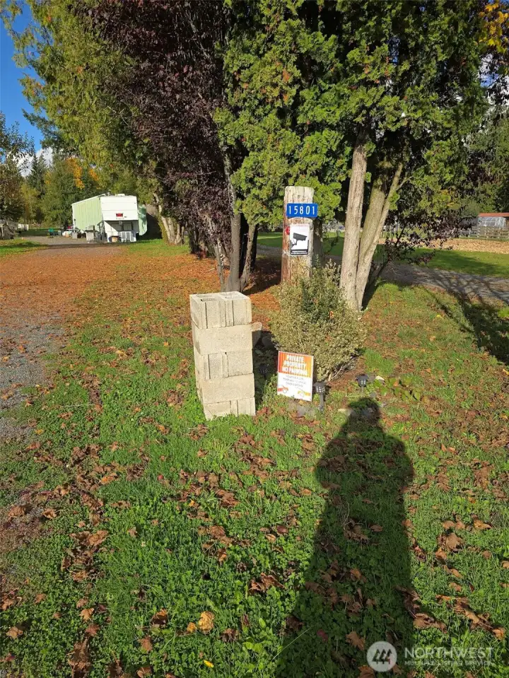 Gravel road entry to the property and storage building and carport.