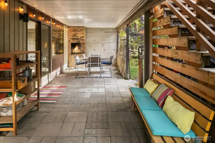 Underneath the deck is a spacious, covered patio with its own built-in fireplace! The stairs on the right head up to the deck off the main floor.