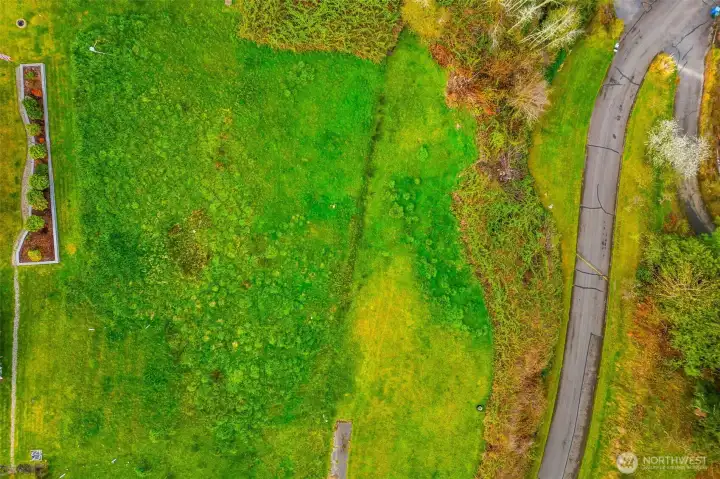 Birds eye view of 0.964 acre lot. Road to community beach boarders on east edge.