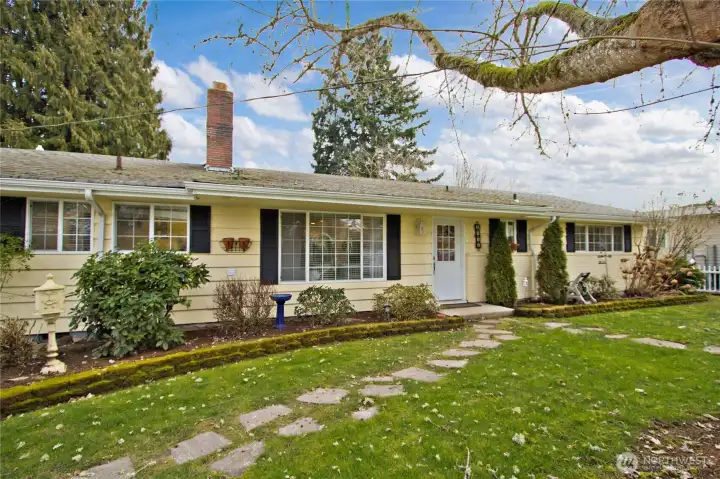 Charming single-level rambler with mature landscaping and inviting curb appeal.
