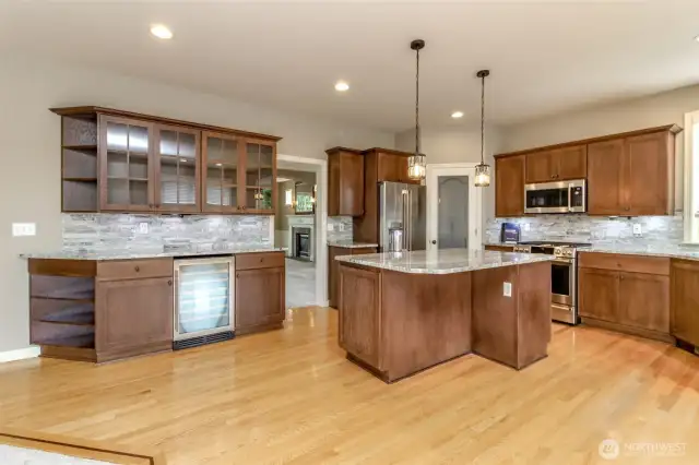 View from the family room into the Kitchen! watch the game while entertaining in your beautiful kitchen! Look at the gorgeous newly stained cabinets< back splash along the entire back & GRANTE slabs!